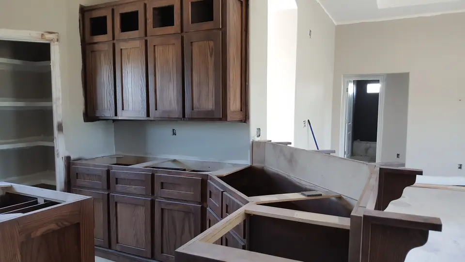 Custom dark wood cabinets and island prepared during a Better Builders kitchen installation.