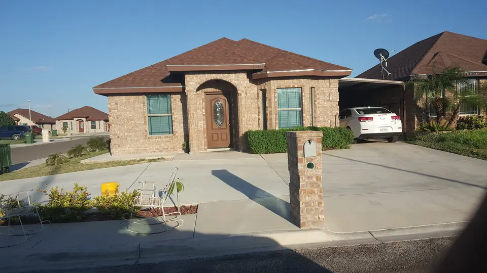 Completed Better Builders brick home with an arched stone entry and front landscaping.