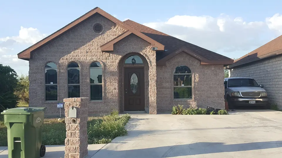 Completed Better Builders home with brick, stone accents, and tall arched windows.
