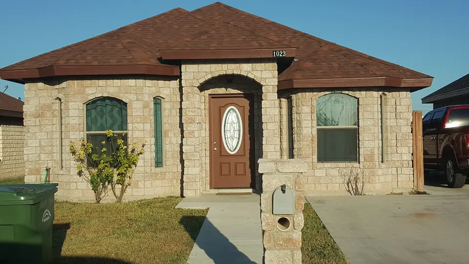 Completed Better Builders light-stone home with an oval-glass entry door.