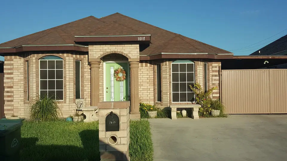 Completed Better Builders stone home with a wide facade and arched windows.