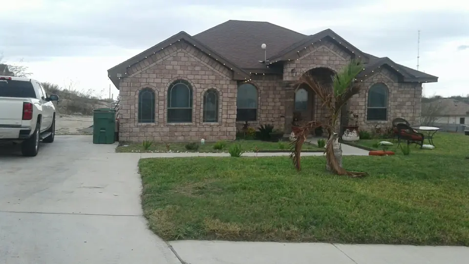 Completed Better Builders brick home with three arched windows and stone accents.