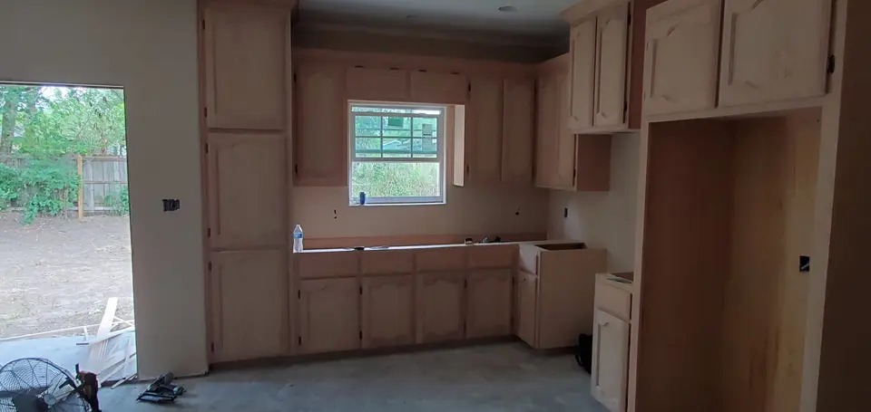 Better Builders kitchen during cabinet installation with custom wood cabinetry in place before countertops and final finishes.