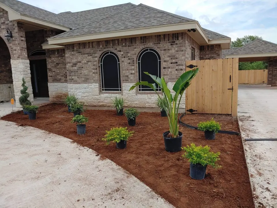 Fresh landscaping installed beside a completed Better Builders brick home.
