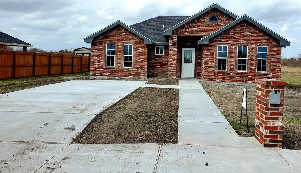 Completed Better Builders red-brick home with stone accents and finished driveway.