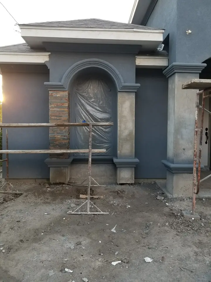 Arched front-entry stucco trim and stone accent work under construction on a Better Builders home.
