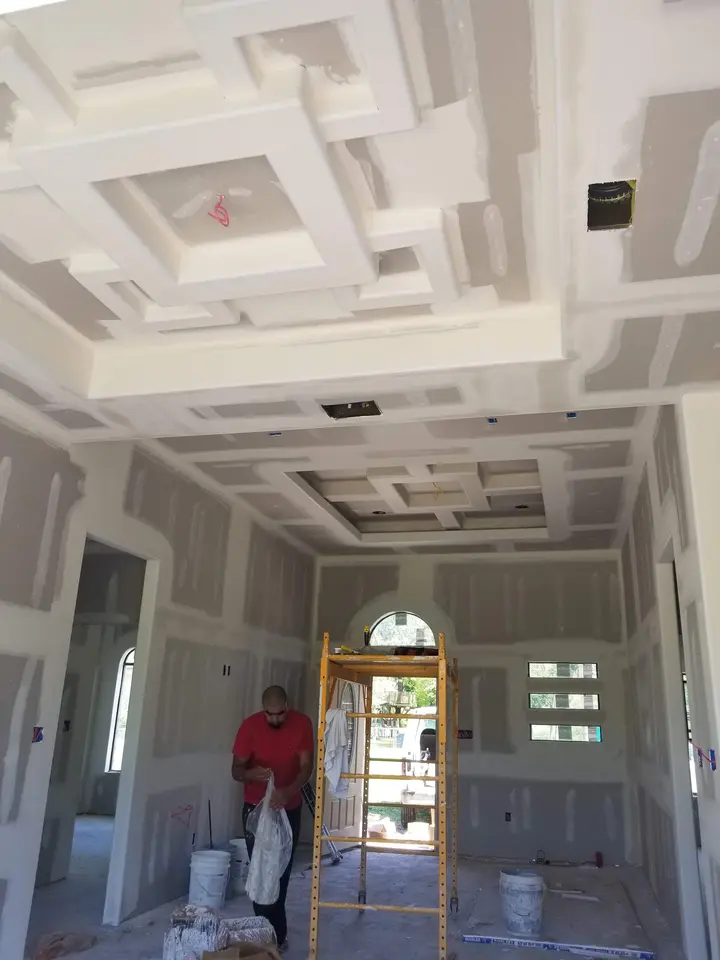 Large custom coffered ceiling and drywall finish work underway inside a Better Builders home.