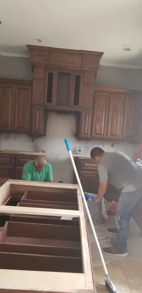 Craftsmen installing cabinet components for a large kitchen island inside a Better Builders home.