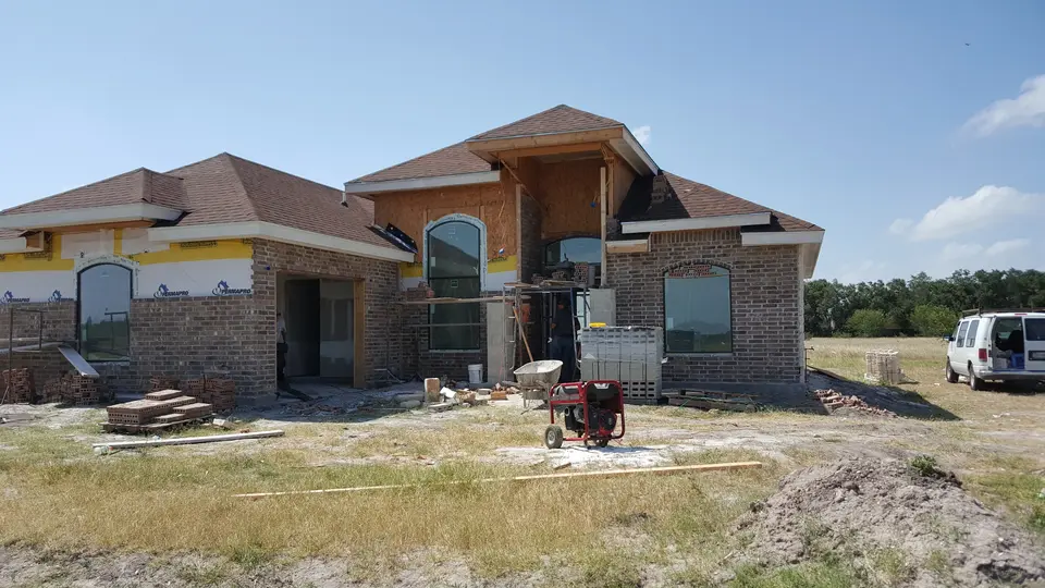 Front of a Better Builders home during brick and stone exterior finish installation.