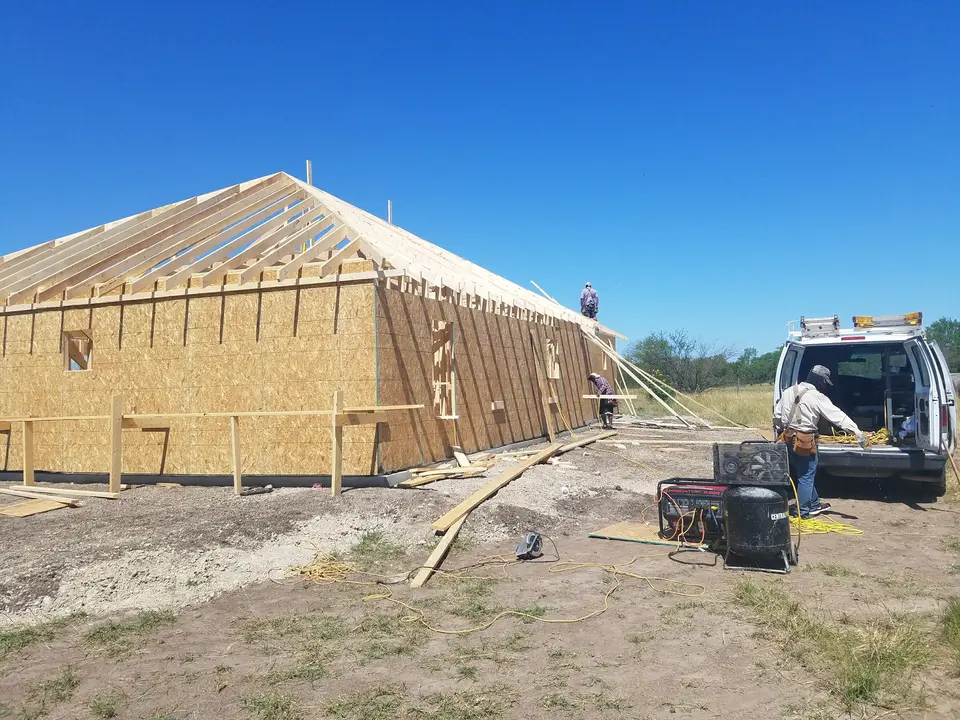 Better Builders home with roof rafters, wall sheathing, and roofing work underway at the jobsite.