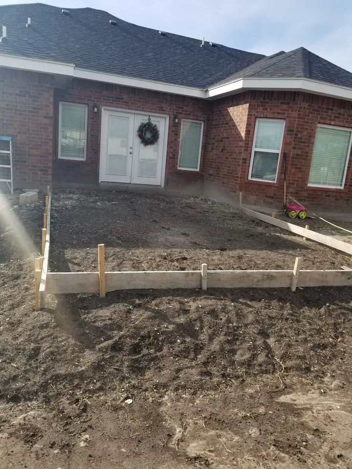 Front exterior of a brick Better Builders home with completed roofing, windows, and entry before final landscaping.