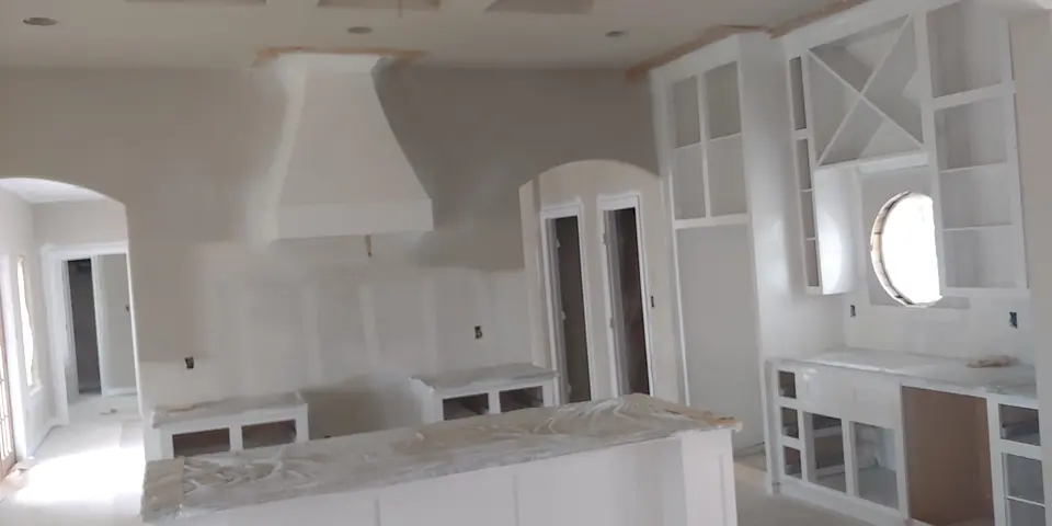 White custom cabinetry and sculpted range hood
