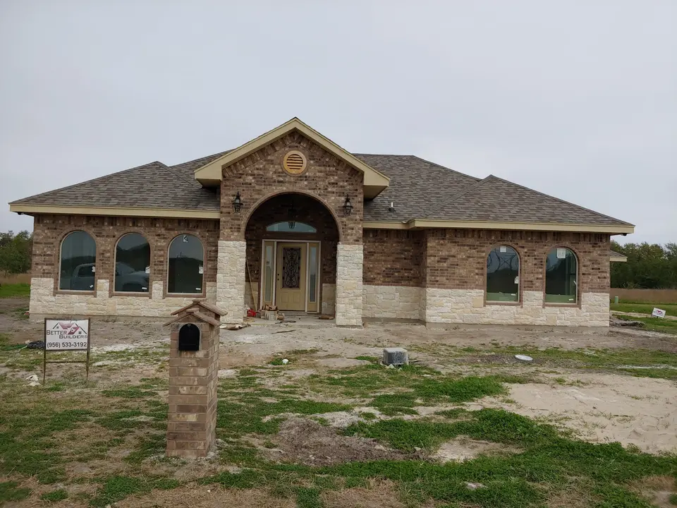 Brick and limestone home with grand arched entry
